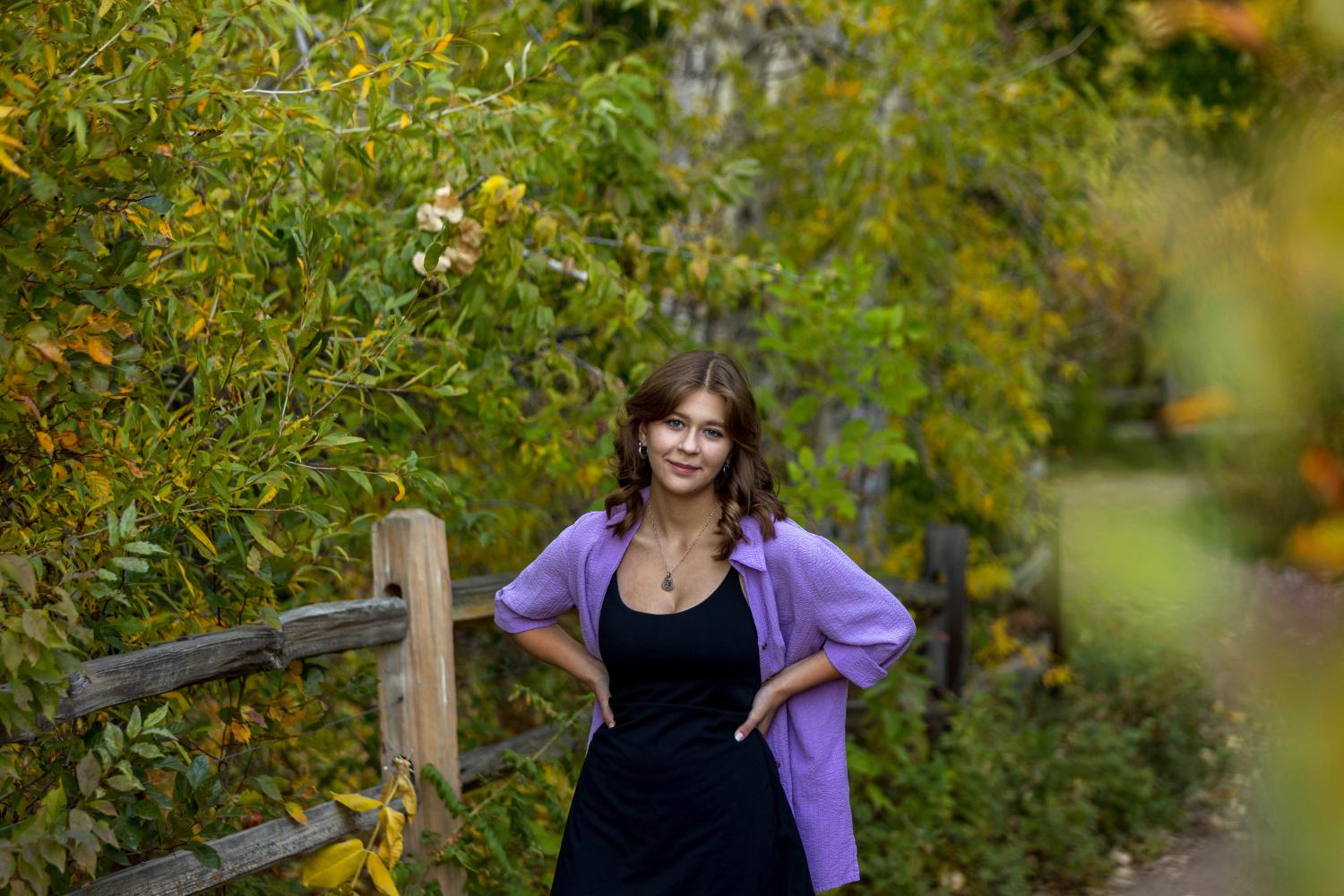 Photo of Julia Harper standing on a path in a very green area with lots of trees.