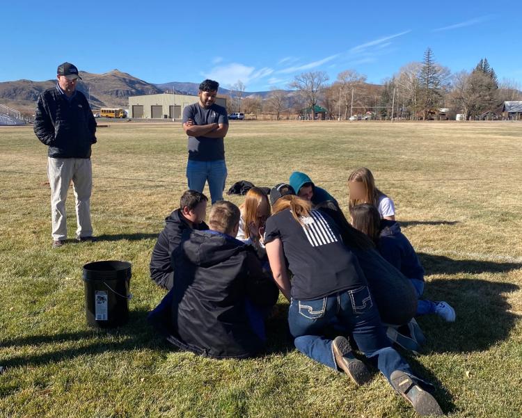 Students huddled together working on an AQIQ project outside