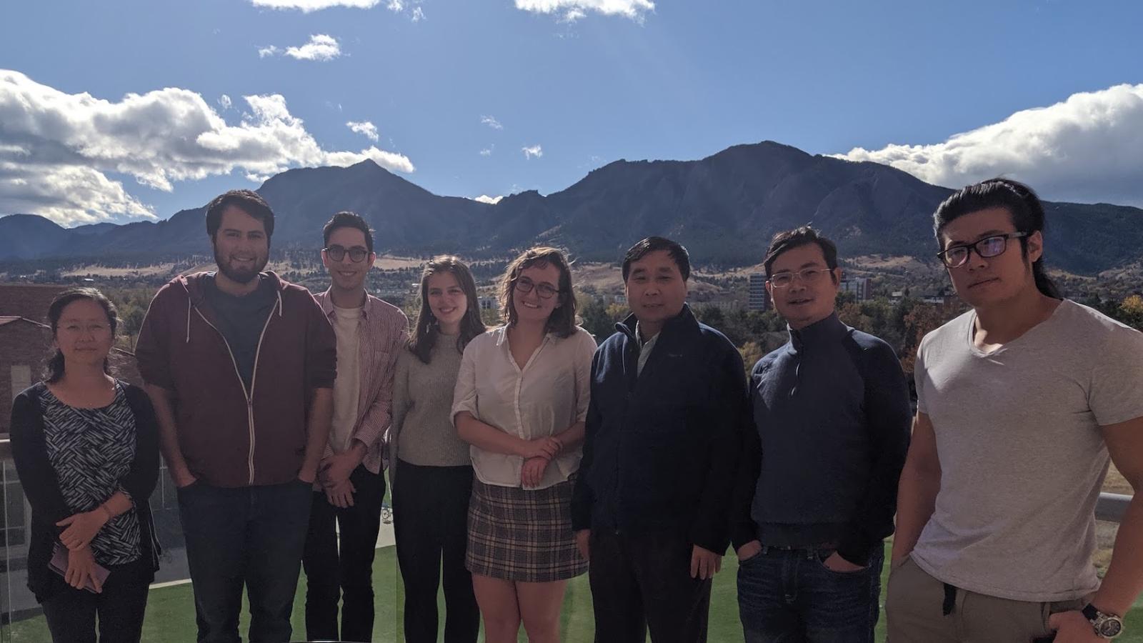 Lab members standing outside with the Flatirons behind them