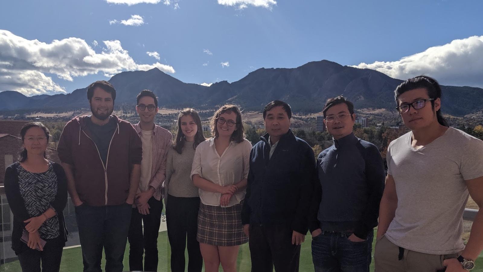 Lab members standing outside with the Flatirons behind them