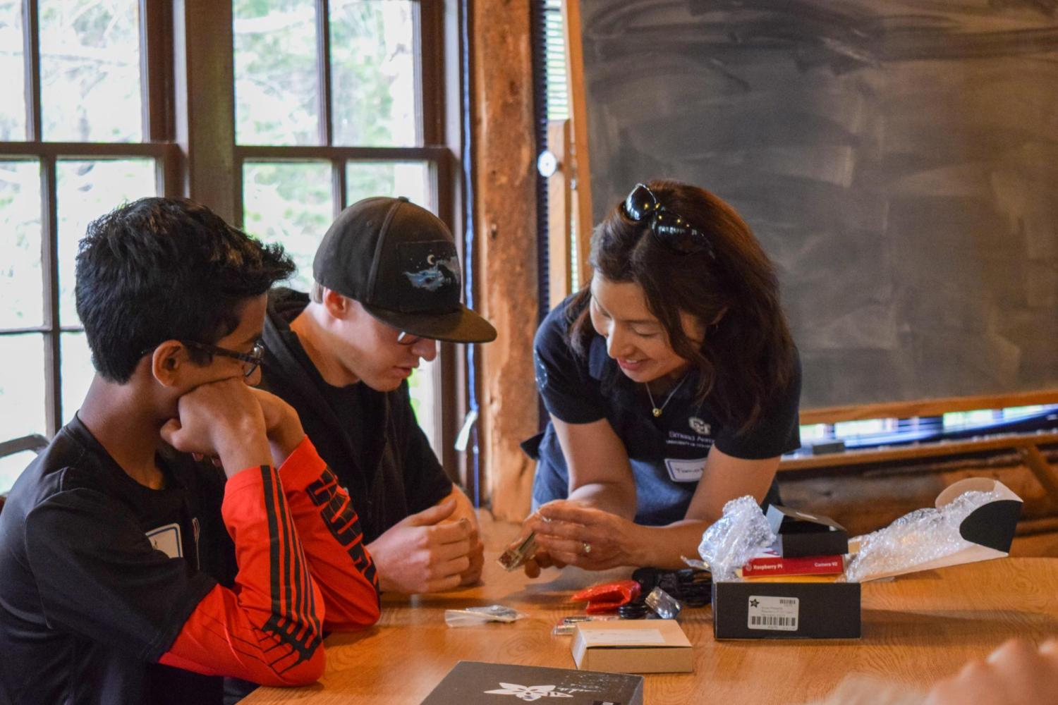 Tomoko Matsuo working with two high school students.