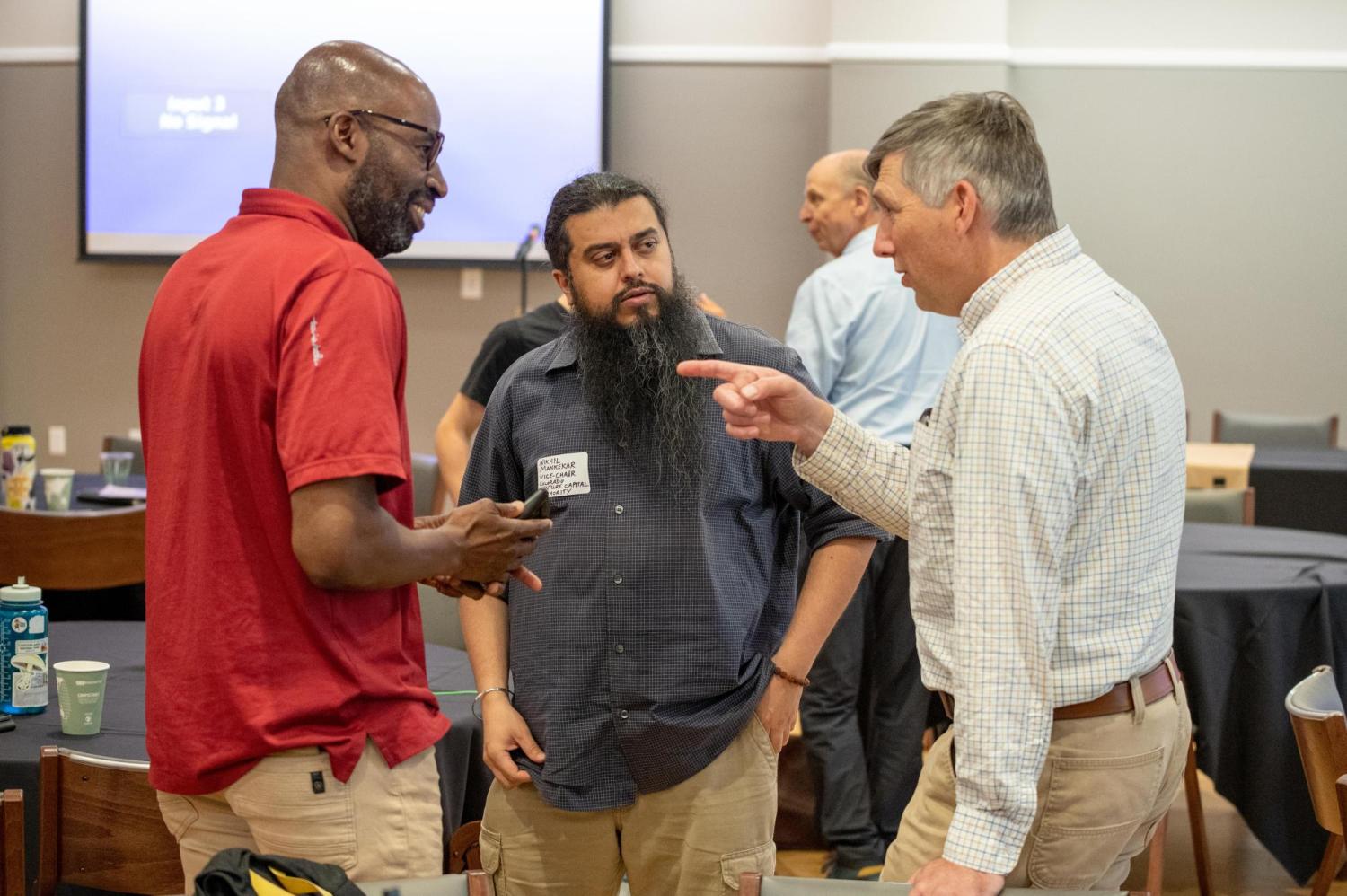 Photograph of three participants at the Local Tech Ecologies conference speaking together