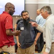 Photograph of three participants at the Local Tech Ecologies conference speaking together