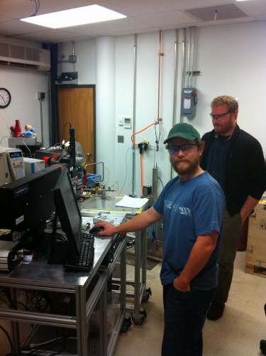 Paul Sandberg with Ben Passey in front of a mass spec in Ben's lab