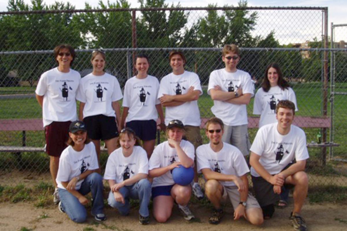 Team posed in front of fence