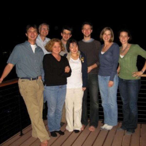 Past group members posing on a deck