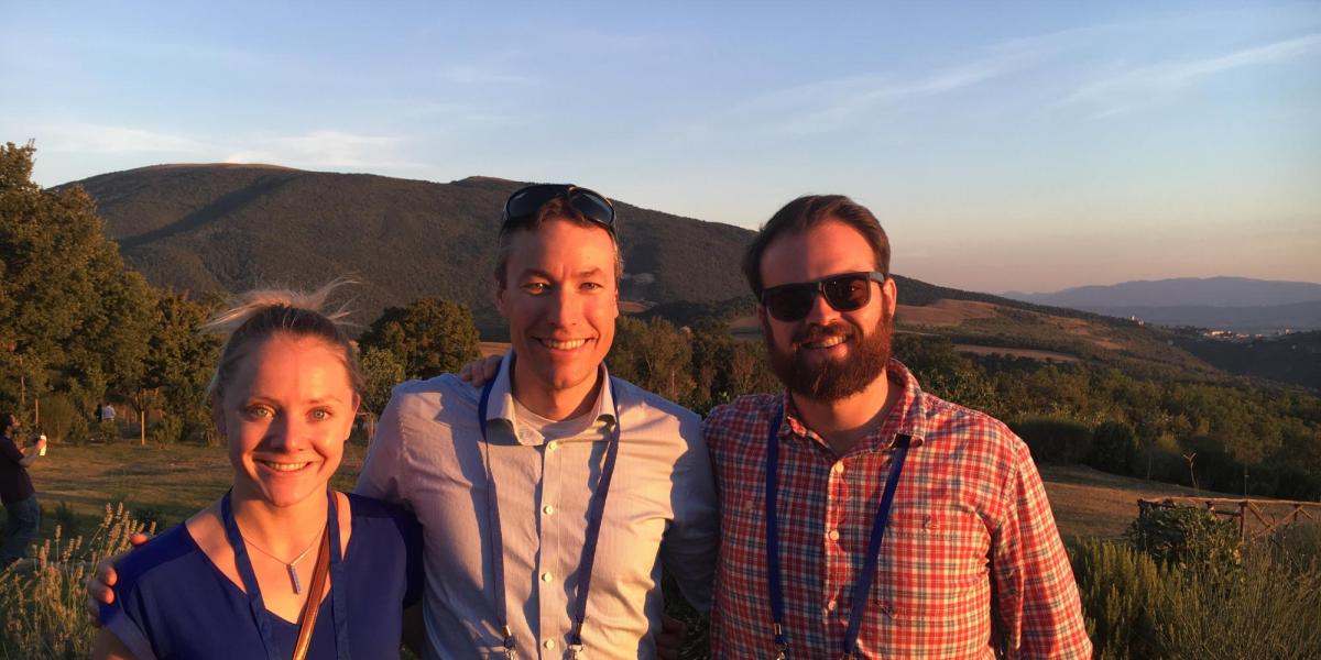 Greg Rieker with two of his students posing with a mountain