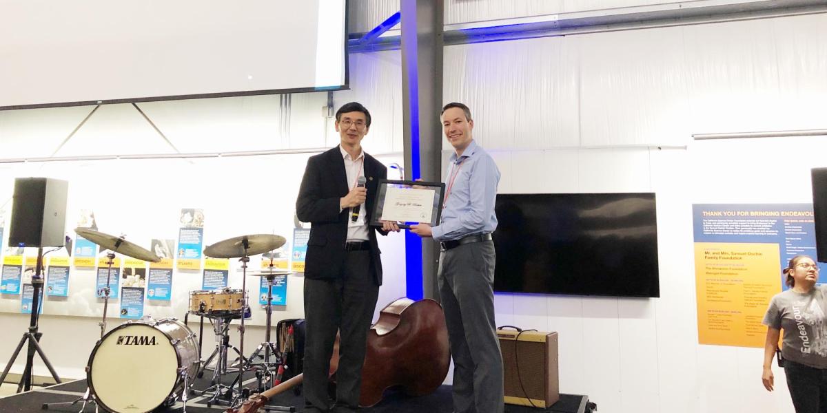 Greg and Yiguang holding up an award