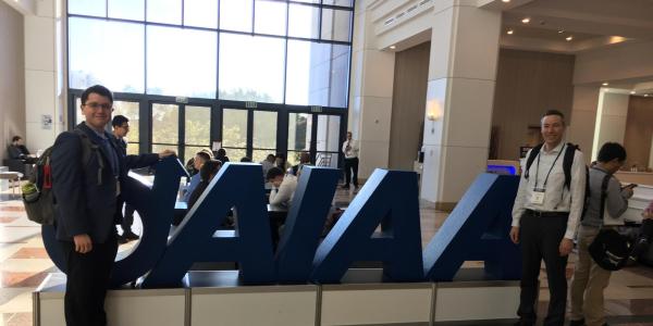 Greg and his student posing in front of the AIAA sign in San Diego