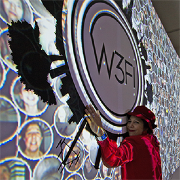 a woman hugging an image projected onto the wall that says W3F1