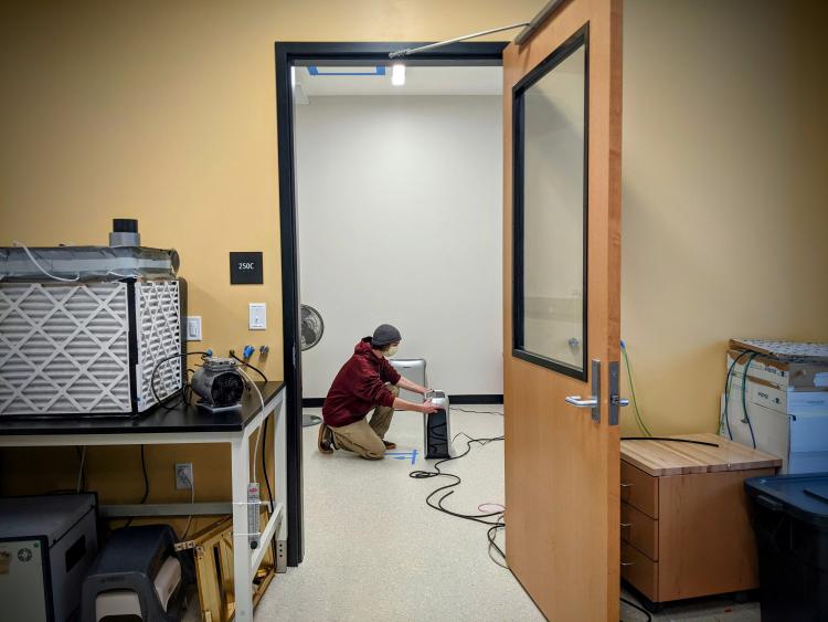 MS student Andrew Martin in the air quality laboratory with a portable air cleaner.