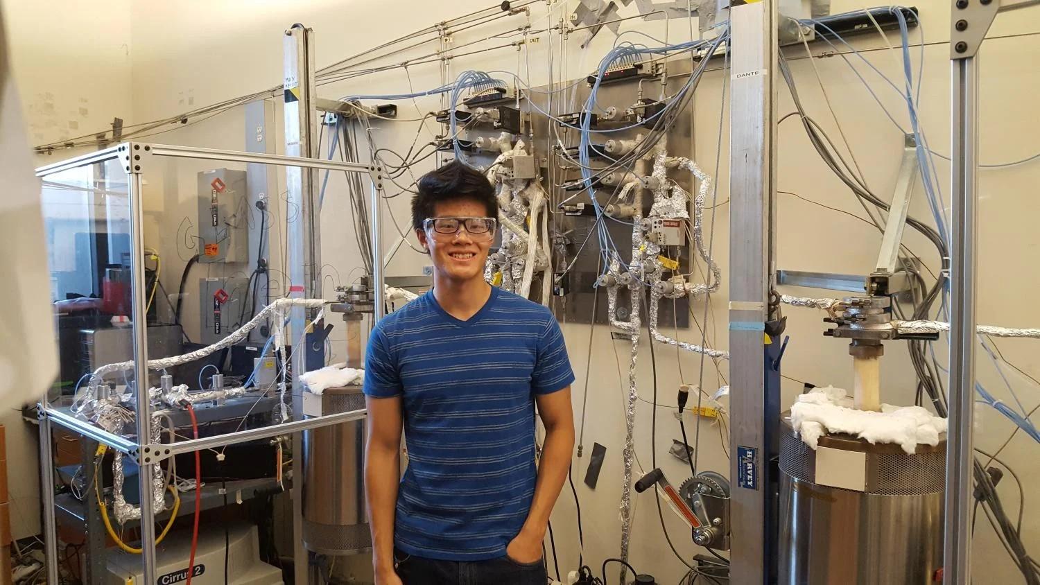 Kevin Sun next to Moses and Dante, the stag flow reactors used for metal oxide water splitting.