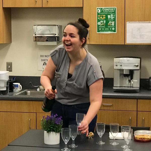 Aly excitedly pours champagne