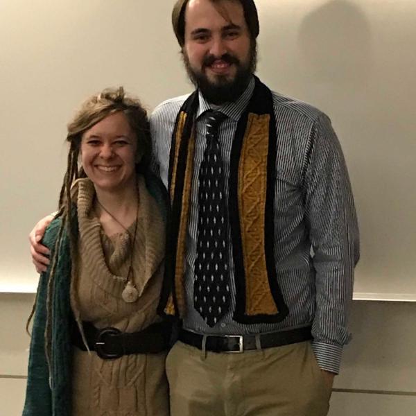 Dani and Neil pose. She has surprised him with a newly knit DNA scarf!