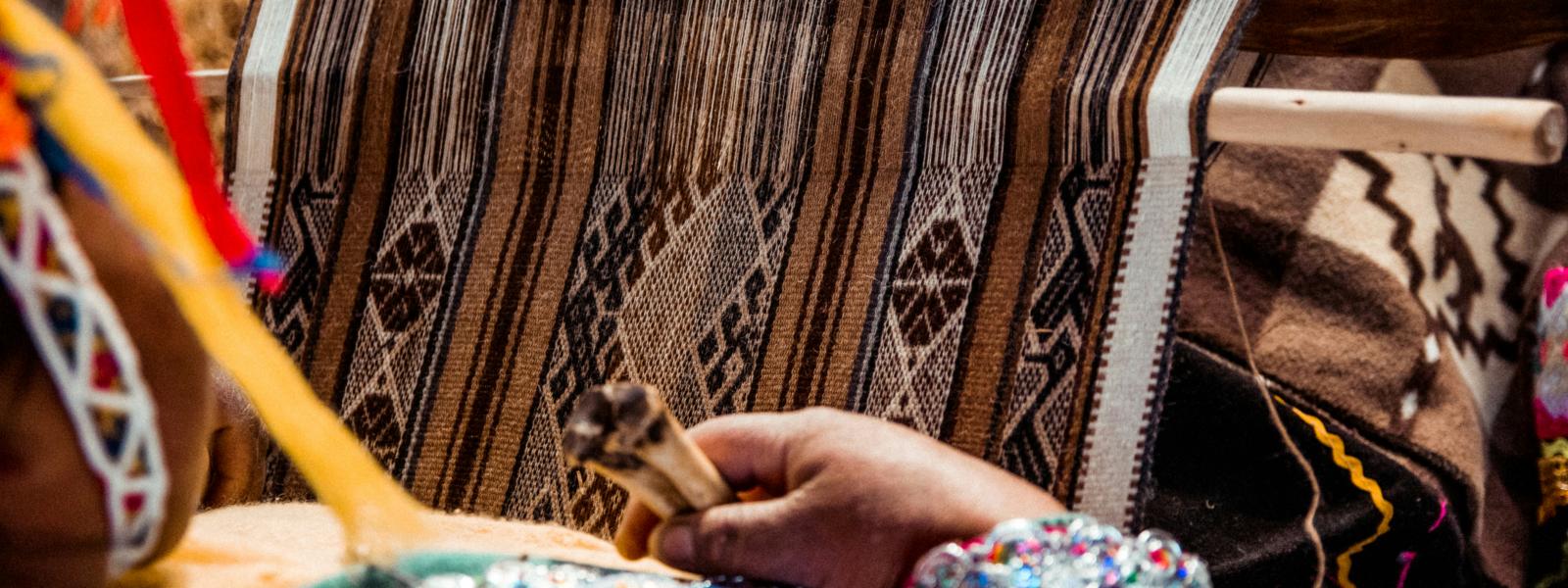 Indigenous woman weaving a patterned textile