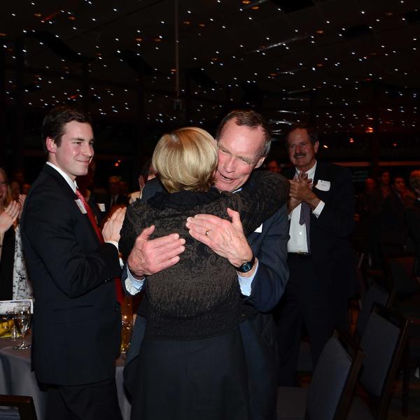 Man hugging woman at award banquet