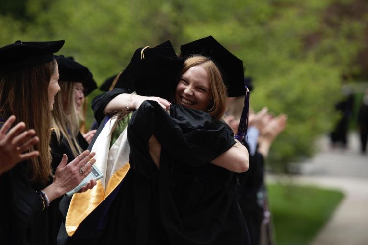 graduates hugging