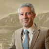 Headshot of Professor Michael Pappas on graphic background