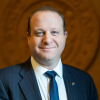 Headshot of Governor Jared Polis against backdrop of mountain landscape
