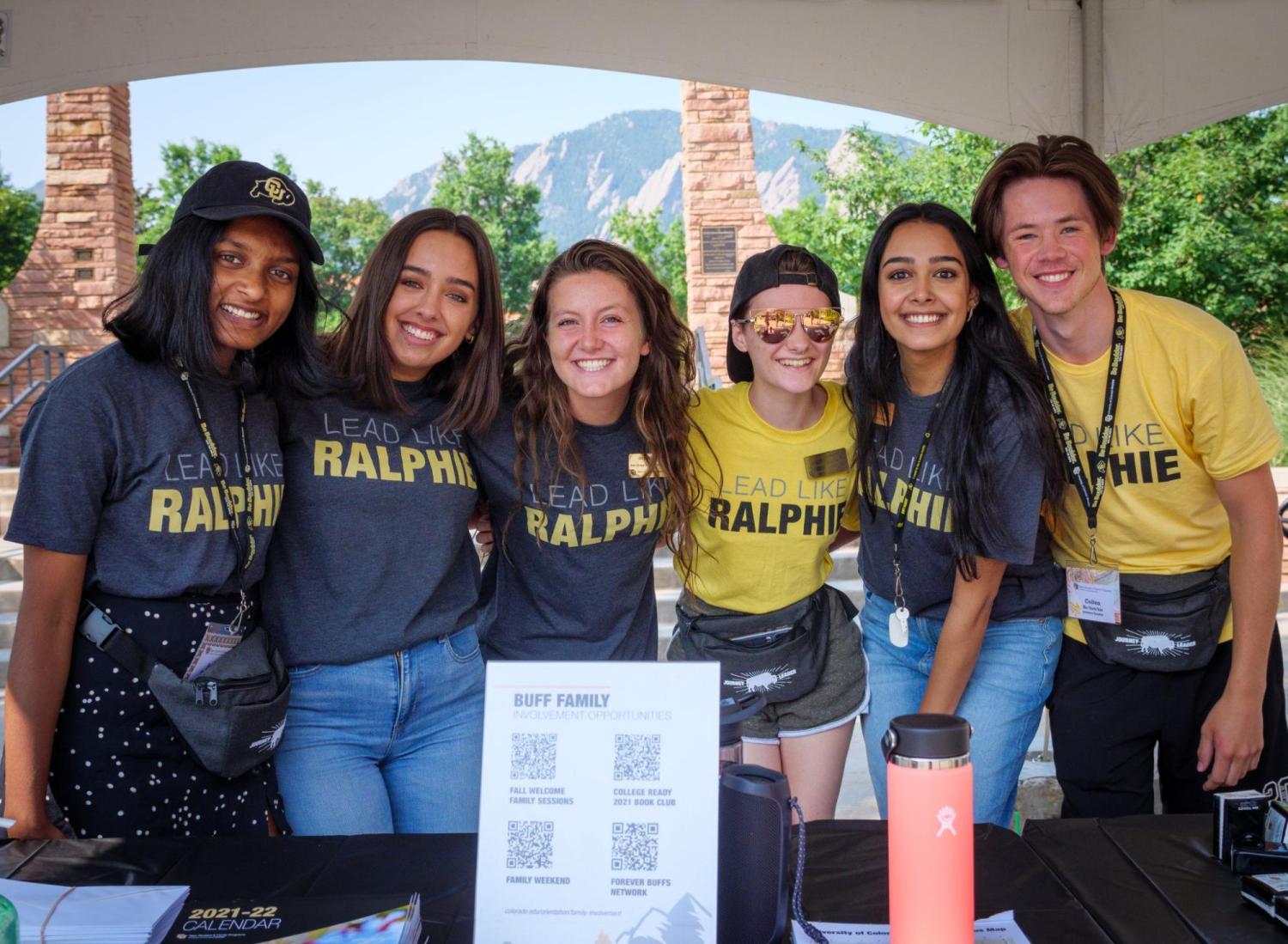 Group of students posing at a table in front of the flatirons