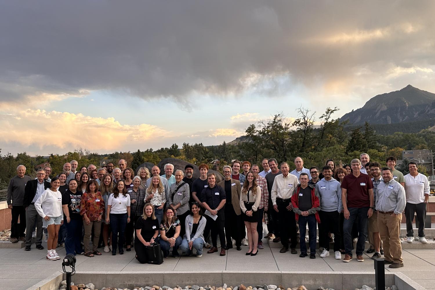 Group of mentors and students pose in front of the flatirons at sunset