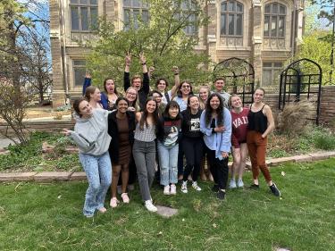 Learning Assistants pose in front of a building