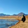 A student kneels by a lake in Chile