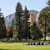 Students sitting in a circle on a grassy field on CU Boulder campus