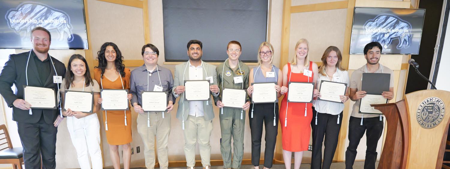 10 Graduating Leaders of the Year smile on stage holding their certificates