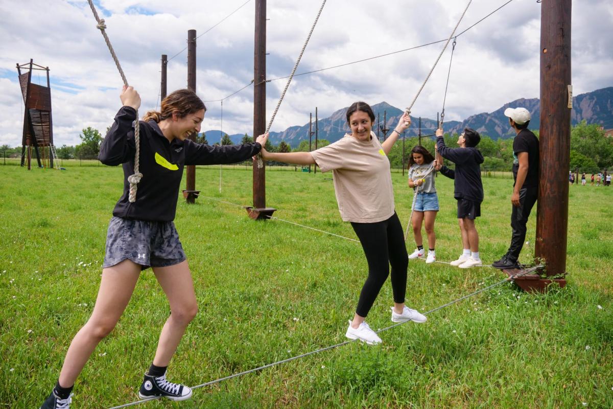 Precollege Bridge program students helping each other through a ropes course