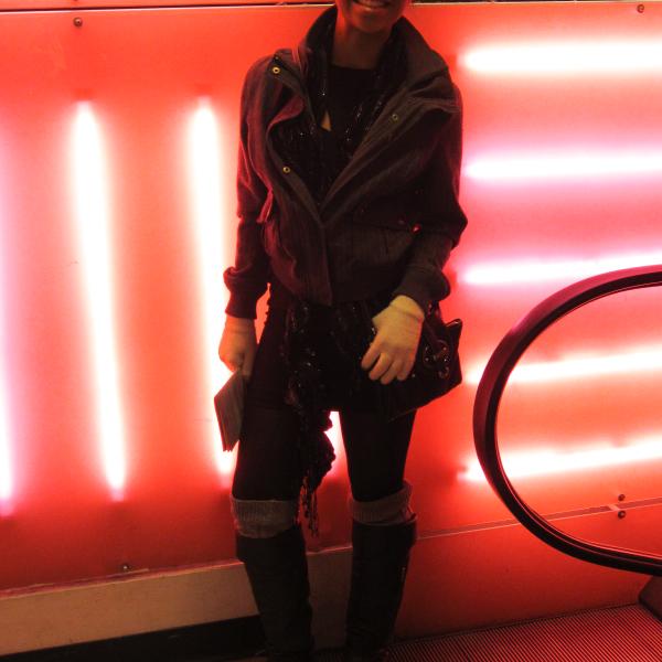 student standing in front of bright pink flourescent lighting