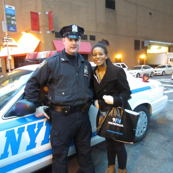 student chatting with officer NYC friendly next to NYC police car