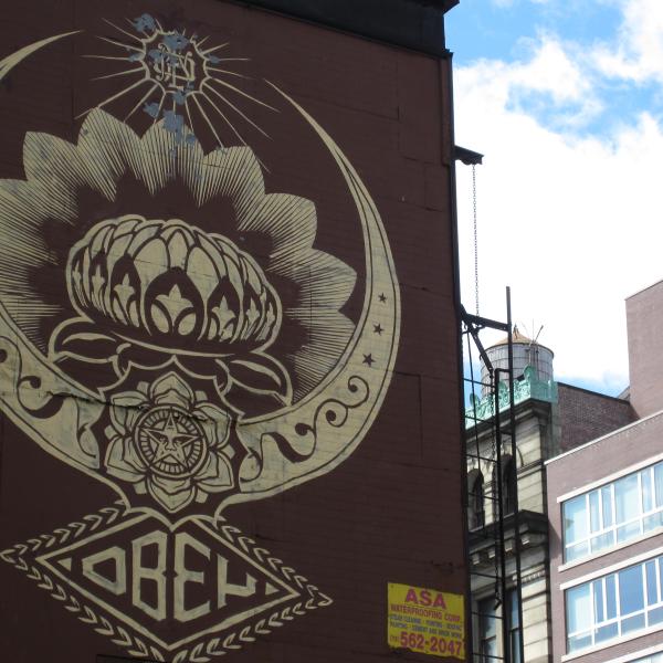 black-and-white mural of lotus flower/jewel design, "Obey"