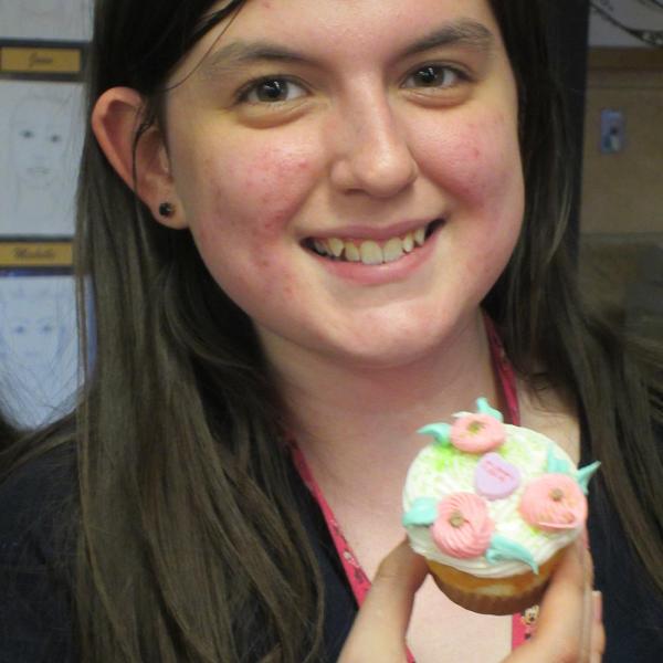 a student has frosted a cupcake for her friend