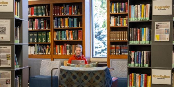 Student studying next to the popular reading collection