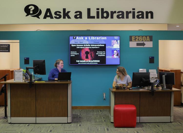 Two librarians at the Ask A Librarian desk