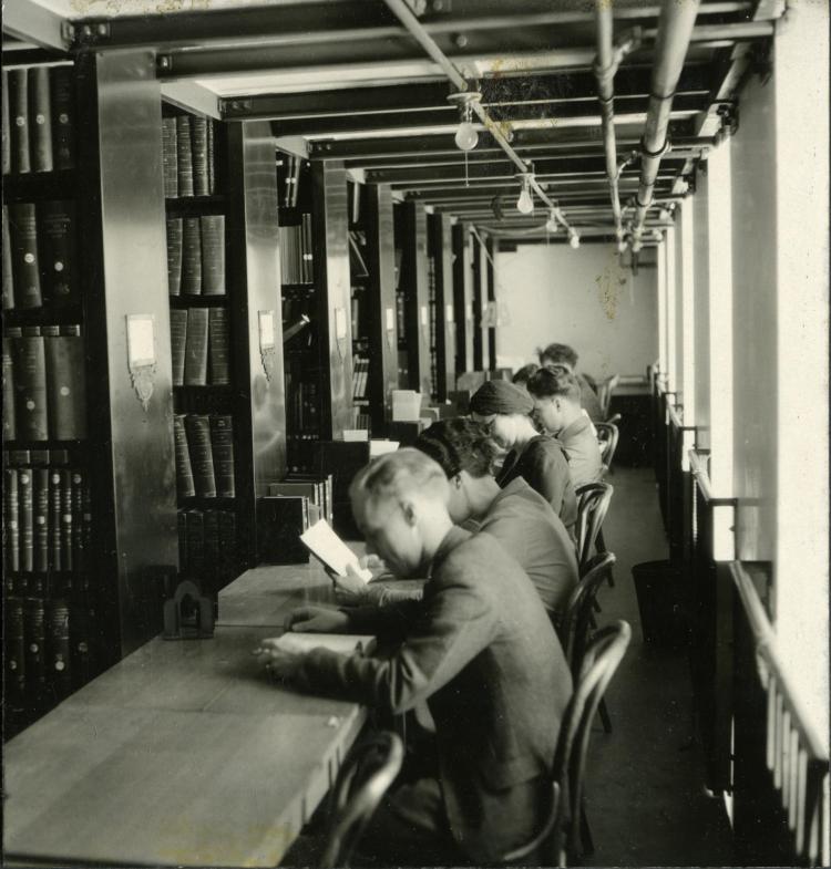 Students sitting at a table studying during finals week from 1933 at Norlin Library