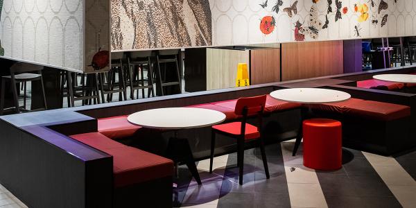 A well-lit restaurant interior features brightly-colored seating.