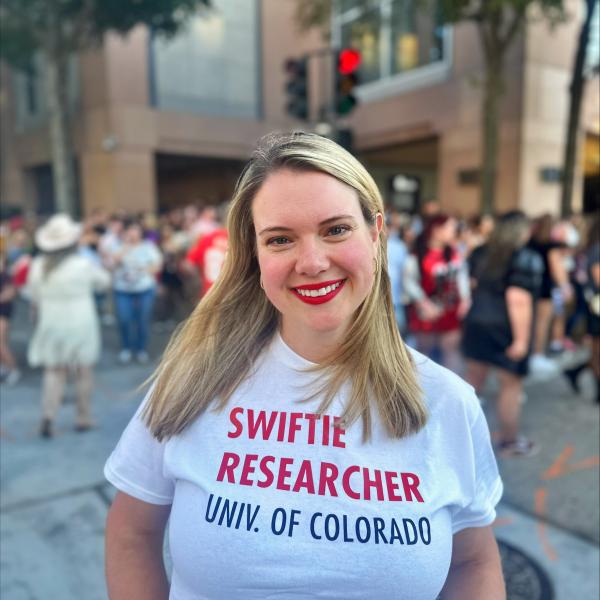 Kate Arnold-Murray wearing a shirt that reads, Swiftie Researcher, Univ. of Colorado