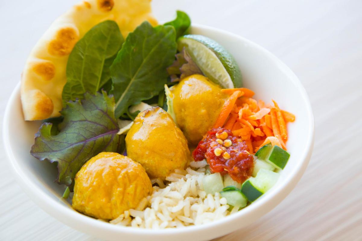 Curry bowl with chicken, rice, fresh greens and naan
