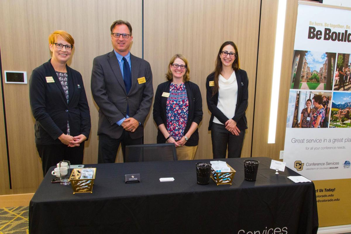 CUCS staff posting behind an adorned registration table