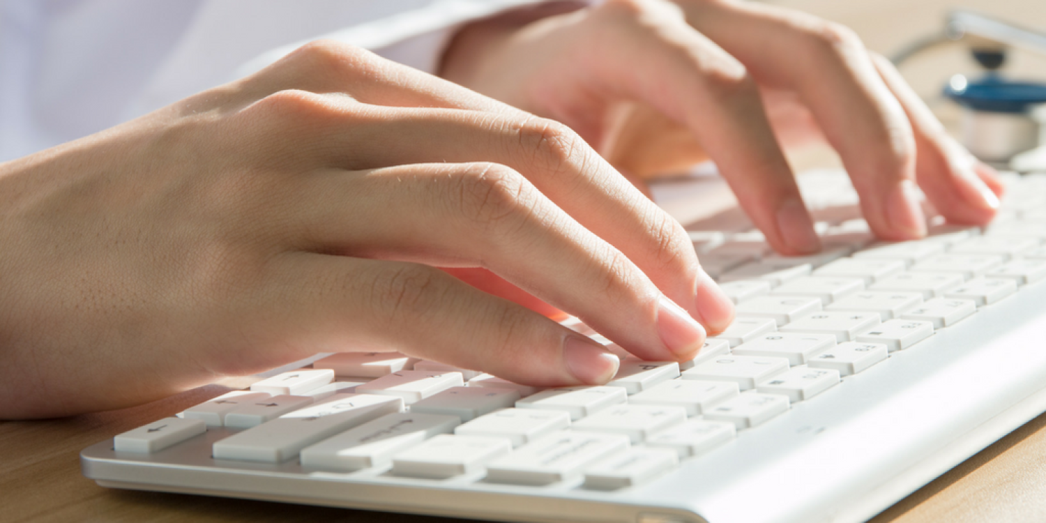 Two hands typing on a keyboard