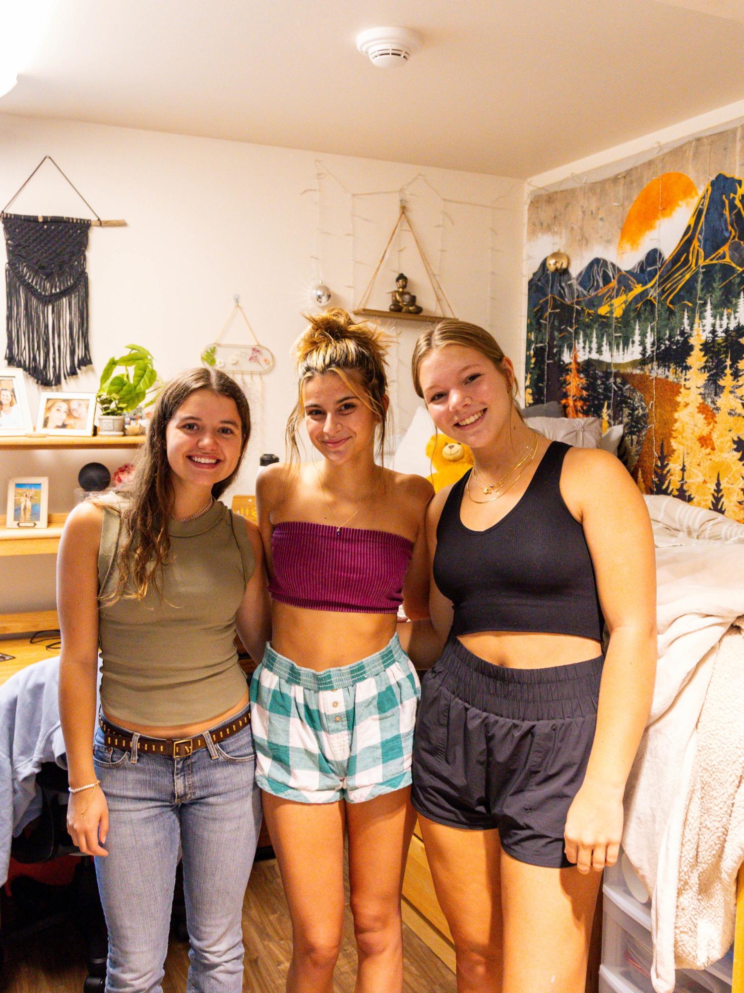 Three students standing in a residence hall