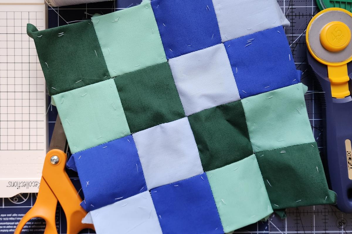 a photo of a 4x4 quilted collection of squares in blue and green