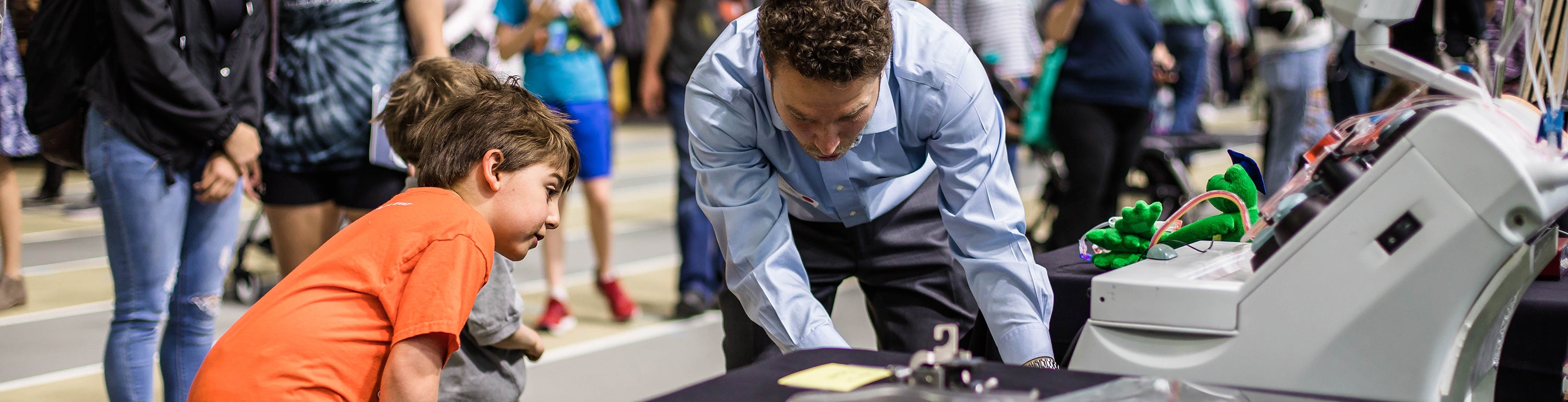 graduate student showing children his engineering project