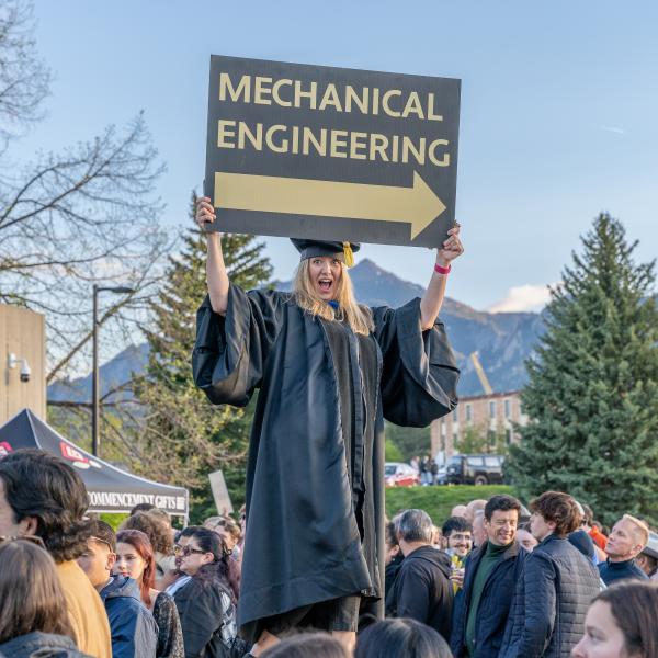 Woman holding a sign that says "mechanical engineering"