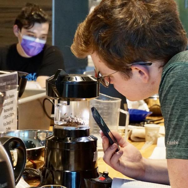 Student watches as beans are roasted