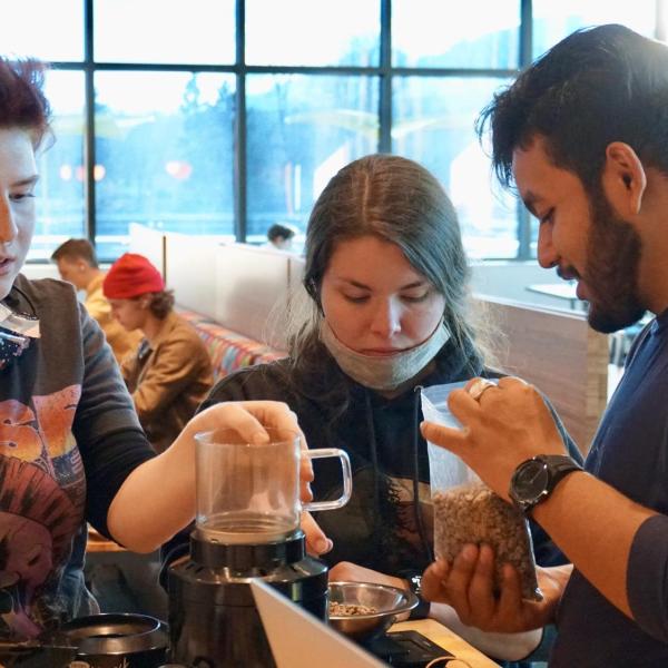 Bex Mikofsky, Demi Dayton and Osmar Aguirre prepare to roast beans