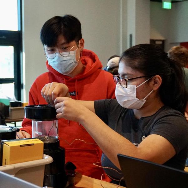 Yiwen Shen and Dulce Gonzales-Beltran prepare to roast beans