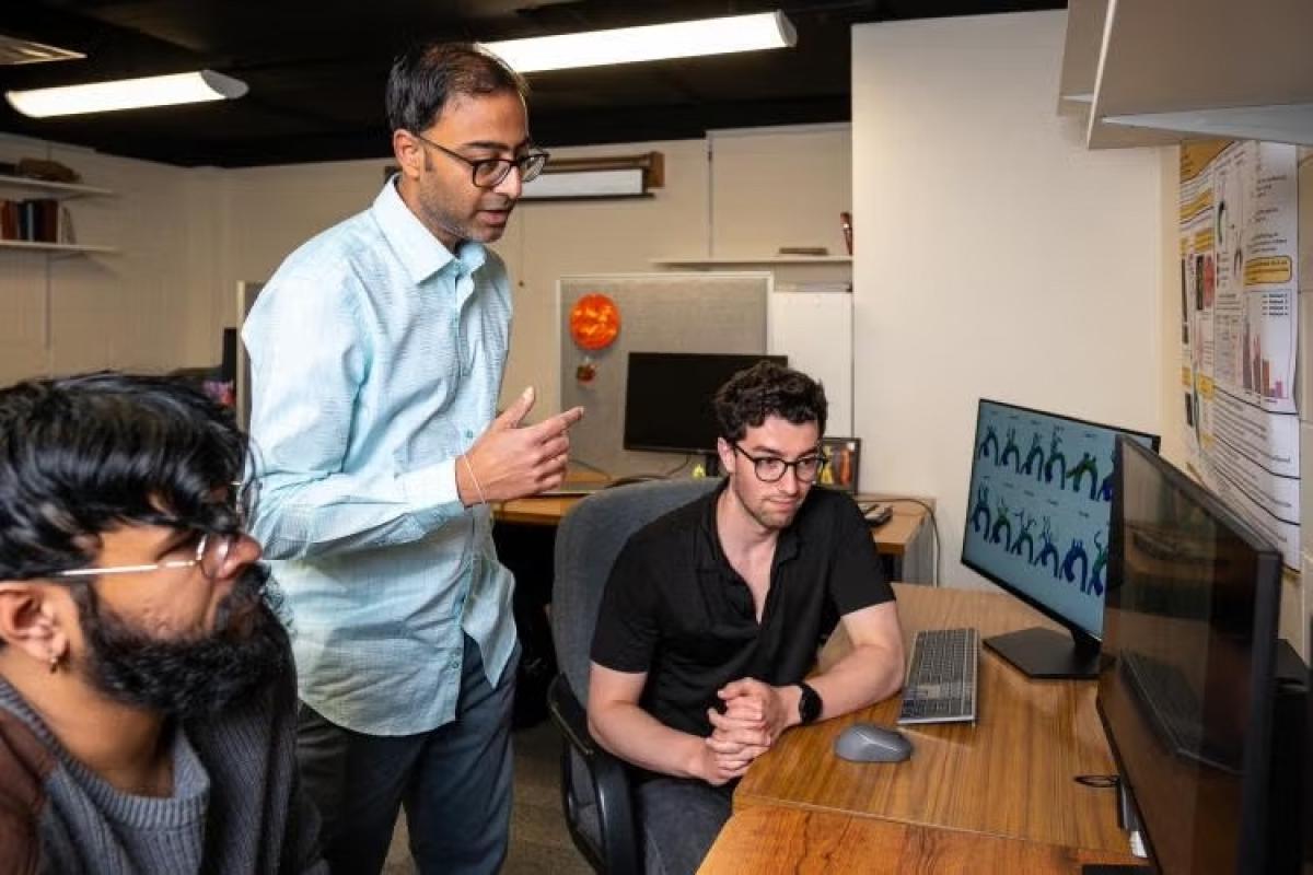 professor and students talking in front of a computer
